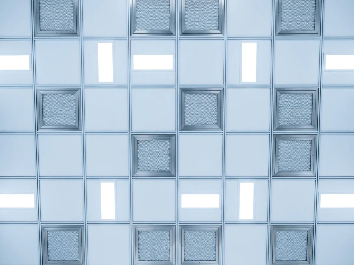 Cleanroom ceiling grid filled with square fan filter units and recessed LED flat lights.